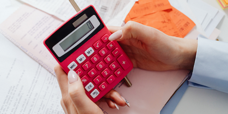 A person using a red calculator
