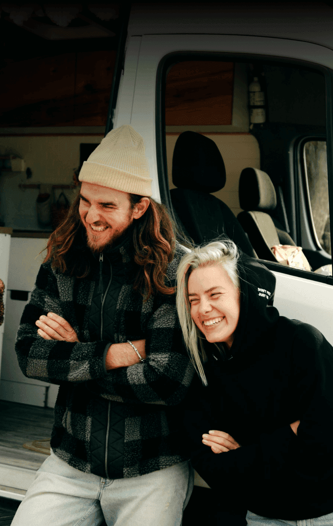 Couple laughing together outside their campervan